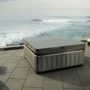 Caldera spa on stone patio with cover on and sea view
