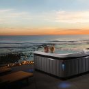Two people talking in Caldera hot tub spa with sea view